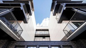 Un edificio moderno con facciata simmetrica, ampie finestre e cielo sereno.