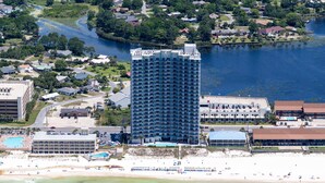A high-rise hotel with a central courtyard, located near a beach and a body of water. - Sterling Breeze 307 (Panama City Beach)