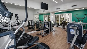 A gym with cardio machines, weight stations, and mirrors. - Landing | Incredible 2BD, Gym, Tennis Court (Palm Bay)