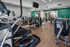 A gym with cardio machines, weight stations, and mirrors. - Landing | Incredible 2BD, Gym, Tennis Court (Palm Bay)