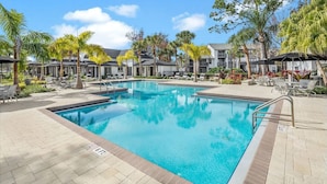 A swimming pool with lounge chairs and palm trees. - Landing | Incredible 2BD, Gym, Tennis Court (Palm Bay)