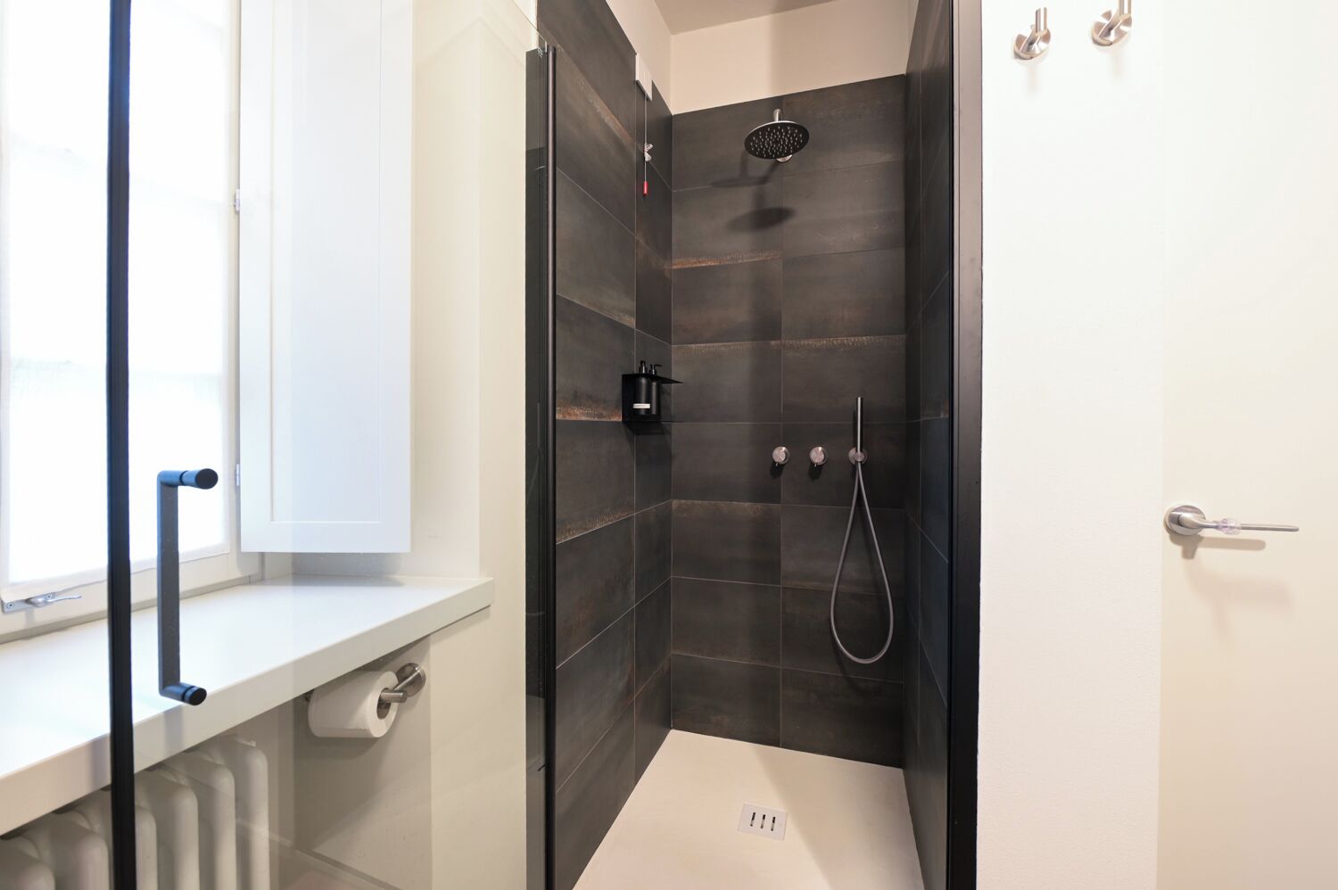 Un baño moderno con ducha, inodoro y ventana.