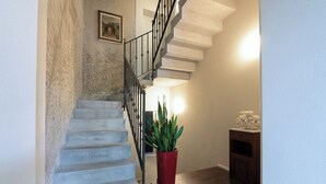 A staircase with a handrail, a potted plant, and a wall-mounted picture. - Villa Bredina (Brescia)