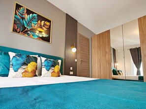 Een moderne slaapkamer met een groot bed, een wanddecoratie, een kledingkast en een spiegel.