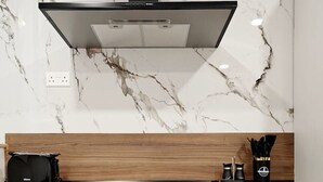 Een moderne keuken met een marmeren spatwand, een houten aanrechtblad en inbouwmeubels.