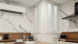 Een moderne keuken met marmeren wanden, een houten eettafel gedekt voor vier personen en een inbouwoven.