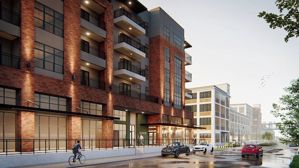 A multi-story building with a brick facade, large windows, and balconies.