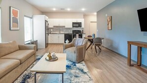 Una sala de estar moderna con un sofá, una mesa de centro y una zona de comedor con una mesa y sillas.