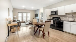 A modern apartment with a dining area, kitchen, and living room. - Landing | Stylish 1BD, Rooftop Lounge, Pool (Memphis)
