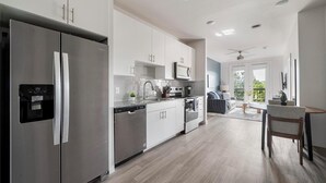A modern kitchen with stainless steel appliances, white cabinetry, and a built-in water dispenser. - Landing | Beautiful 1BD, Gym, Pool (Austin)