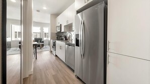 A modern kitchen with stainless steel appliances, a dishwasher, and a refrigerator. - Landing | Stunning Studio, Gym, Pool (Austin)