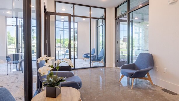 A modern interior with a seating area, large windows, and a potted plant. - Landing | Stunning Studio, Gym, Pool (Austin)