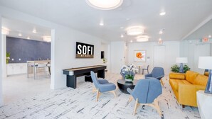 A modern lobby with a pool table, seating area, and a reception desk. - Landing | Stunning Studio, Gym, Pool (Austin)