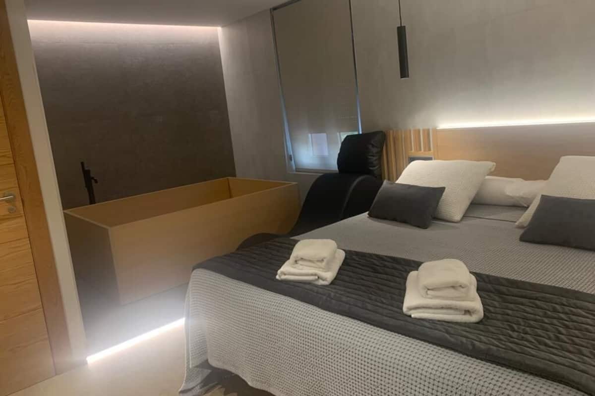 Et moderne hotelværelse med en stor seng, et indbygget badekar og et stort spejl.