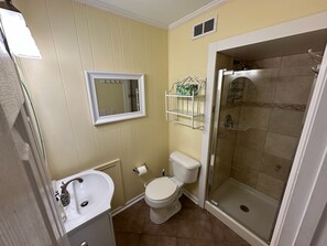 A bathroom with a toilet, sink, and shower. - Anchor & Dreams - Peaceful Updated 2BR Oceanfront Condo (Ocean Isle Beach)