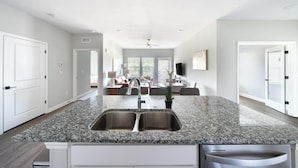 A modern kitchen with granite countertops, stainless steel sinks, and a central island.