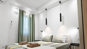 A modern bedroom with a large bed, a bedside table, and a ceiling light fixture. - Valley view 1  2 bedroom aparment (Luqa)