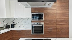 A modern kitchen with a built-in oven, microwave, and stove. - Valley view 2  2 bedroom aparment (Luqa)