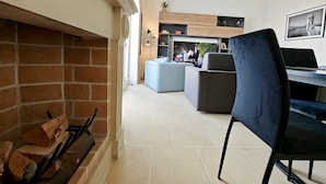 Ein modernes Wohnzimmer mit Kamin, einer Couch und einem Essbereich.