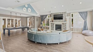 A spacious living area with a stone fireplace, a pool table, and a large L-shaped sofa. - Landing | Stunning 2BD, Gym, Clubhouse (Norfolk)