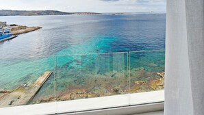Un balcon offrant une vue dégagée sur une zone côtière, comprenant une étendue d’eau et des terres situées au loin.