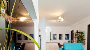 Un salon moderne avec un canapé de couleur turquoise, une table basse et une plante en pot.