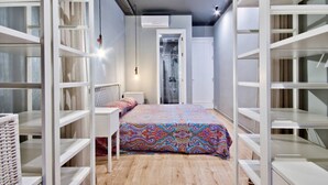 Un dormitorio con cama, un armario blanco y un baño con ducha.