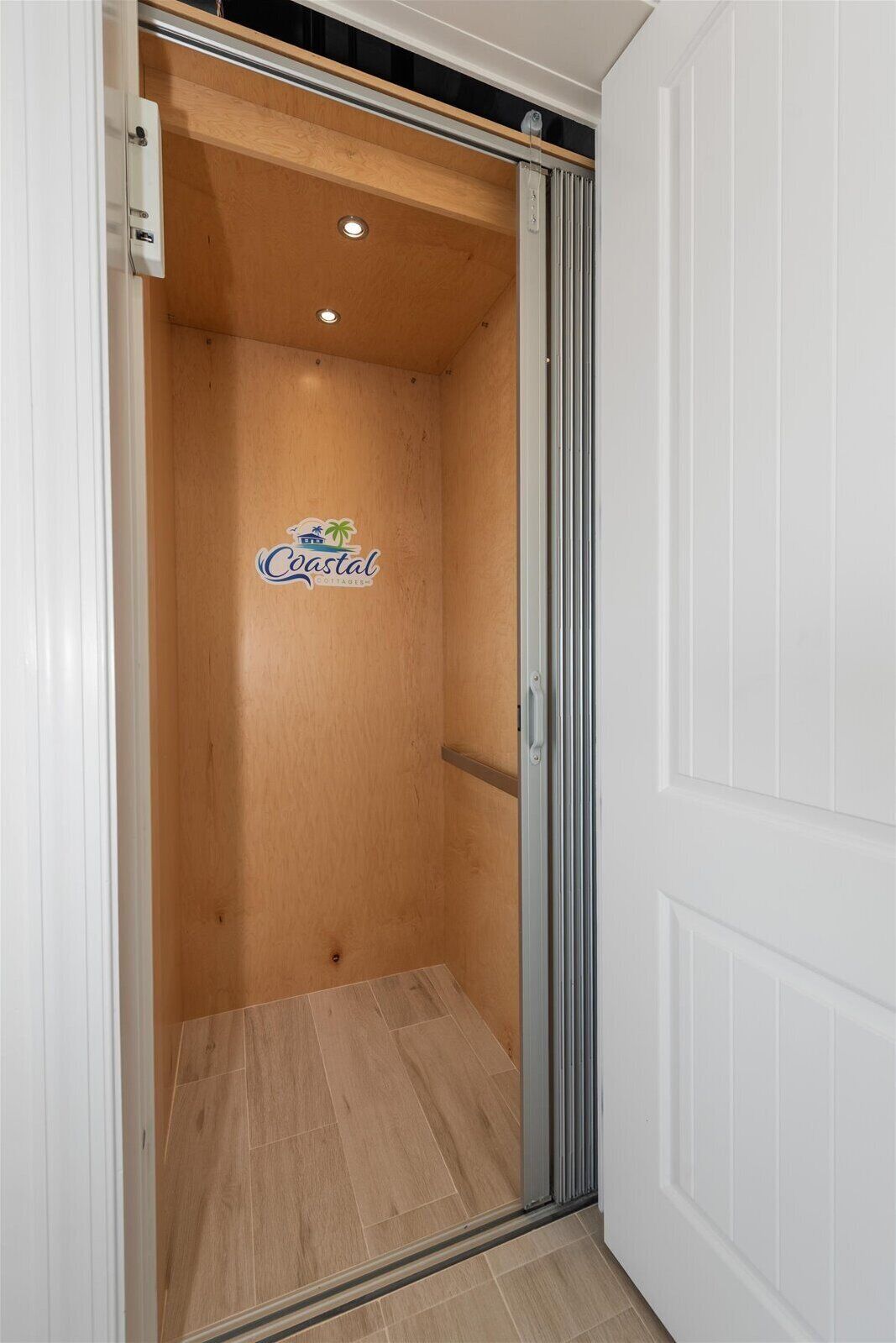 A wooden interior with a logo on the wall, a sliding door, and a light fixture.