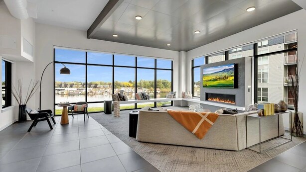 A spacious living room with large windows, a fireplace, and a TV. - Landing | Amazing 2BD, Gym (Portland)