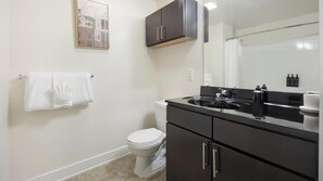 A bathroom with a toilet, sink, and cabinet. - Landing | Chic 1BD, Clubhouse, Gym (Richmond)