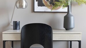 A desk with a black chair, a grey vase with a plant, and a framed artwork on the wall. - Landing | Chic 1BD, Clubhouse, Gym (Richmond)