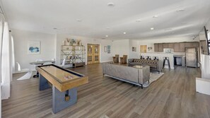 A modern living room with a pool table, a grey sofa, and a kitchen area with stainless steel appliances. - Landing | Chic 1BD, Clubhouse, Gym (Richmond)