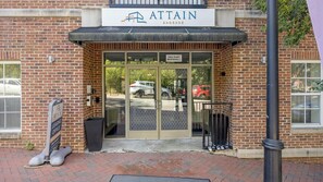 A brick building with a sign reading 'ATTAIN SHOCKOE' and a glass door entrance. - Landing | Chic 1BD, Clubhouse, Gym (Richmond)