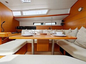 Una cocina compacta con comedor, equipada con estufa, pileta y un refrigerador pequeño.
