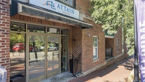 A brick building with a storefront labeled 'ATTAIN' and a sign indicating '1903 EAST MARSHALL'. - Landing | Incredible 2BD, Courtyard (Richmond)