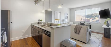A modern kitchen with a central island, stainless steel appliances, and pendant lighting.