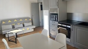 Una cocina moderna con armarios grises, una encimera blanca y un horno empotrado.
