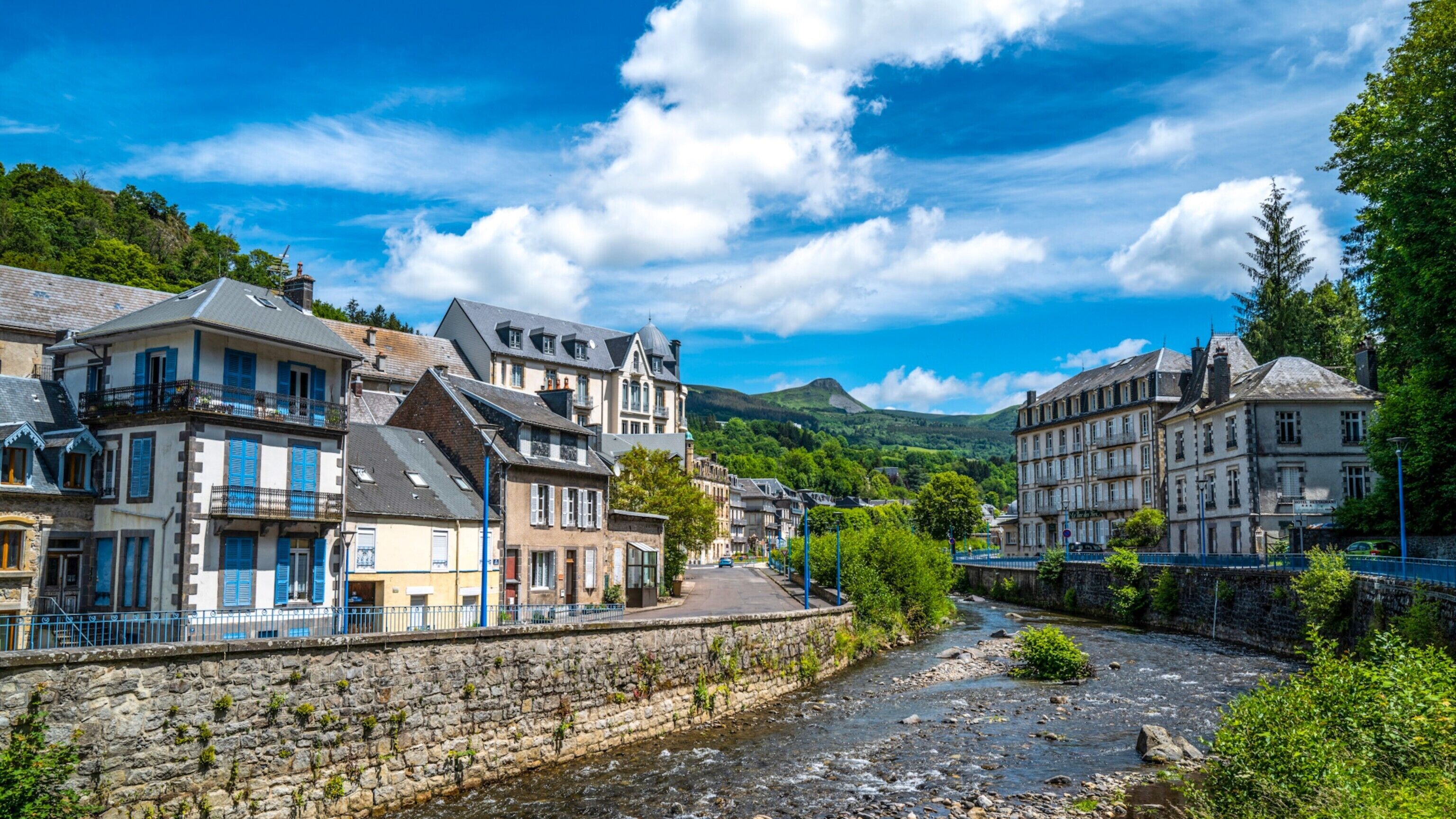 A river running through a town with historic buildings on either side.