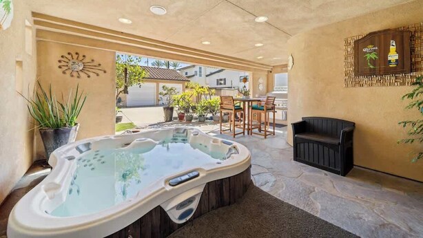 Ein Whirlpoolbereich mit Terrasse, Sitzgelegenheiten und einer Zierwand.
