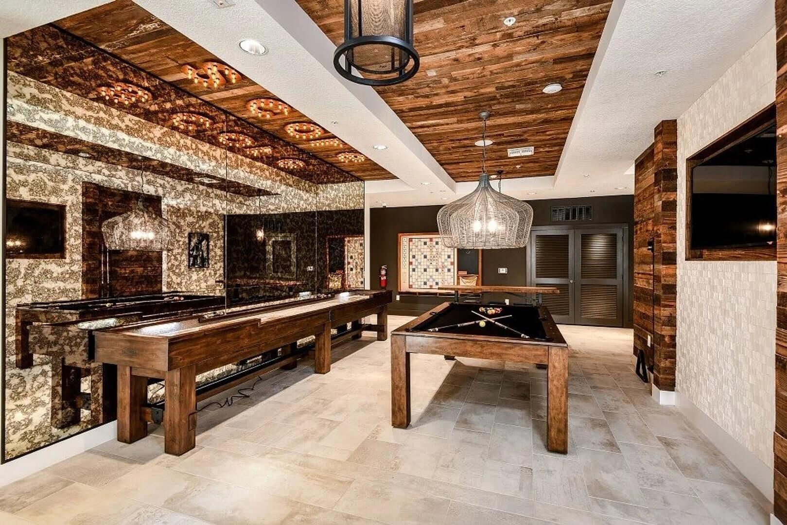Une cuisine moderne avec un billard, des armoires en bois et un lustre.