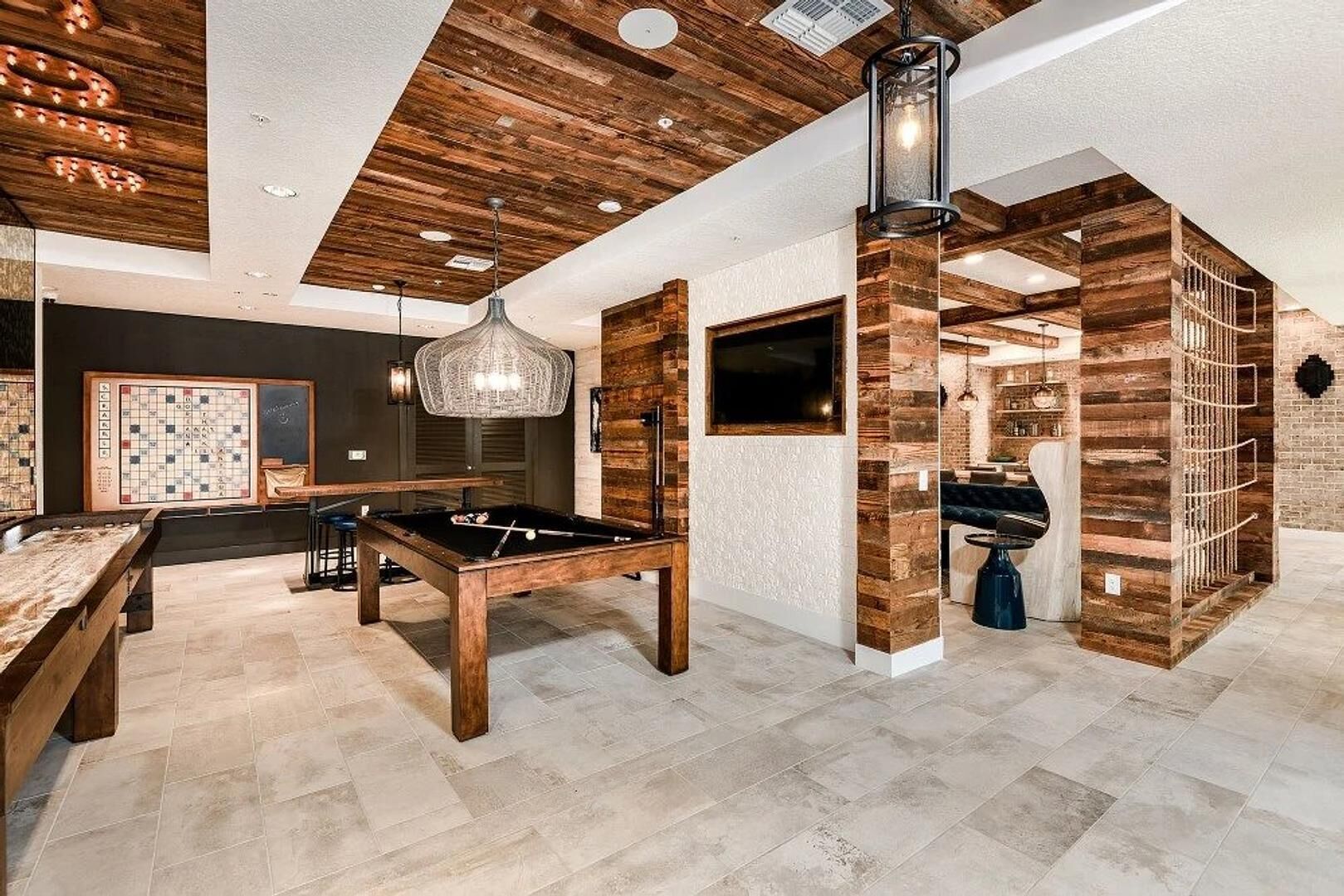 A modern indoor space with a pool table, a billiards table, and a cozy seating area.