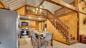 Un intérieur en bois comprenant un coin repas, une cuisine et un escalier.