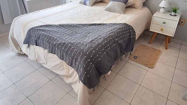 A bedroom with a bed, a nightstand, a lamp, and a window with curtains. - Loft céntrico | Kilómetro 0 | Fast WiFi | Moderno (Montevideo)