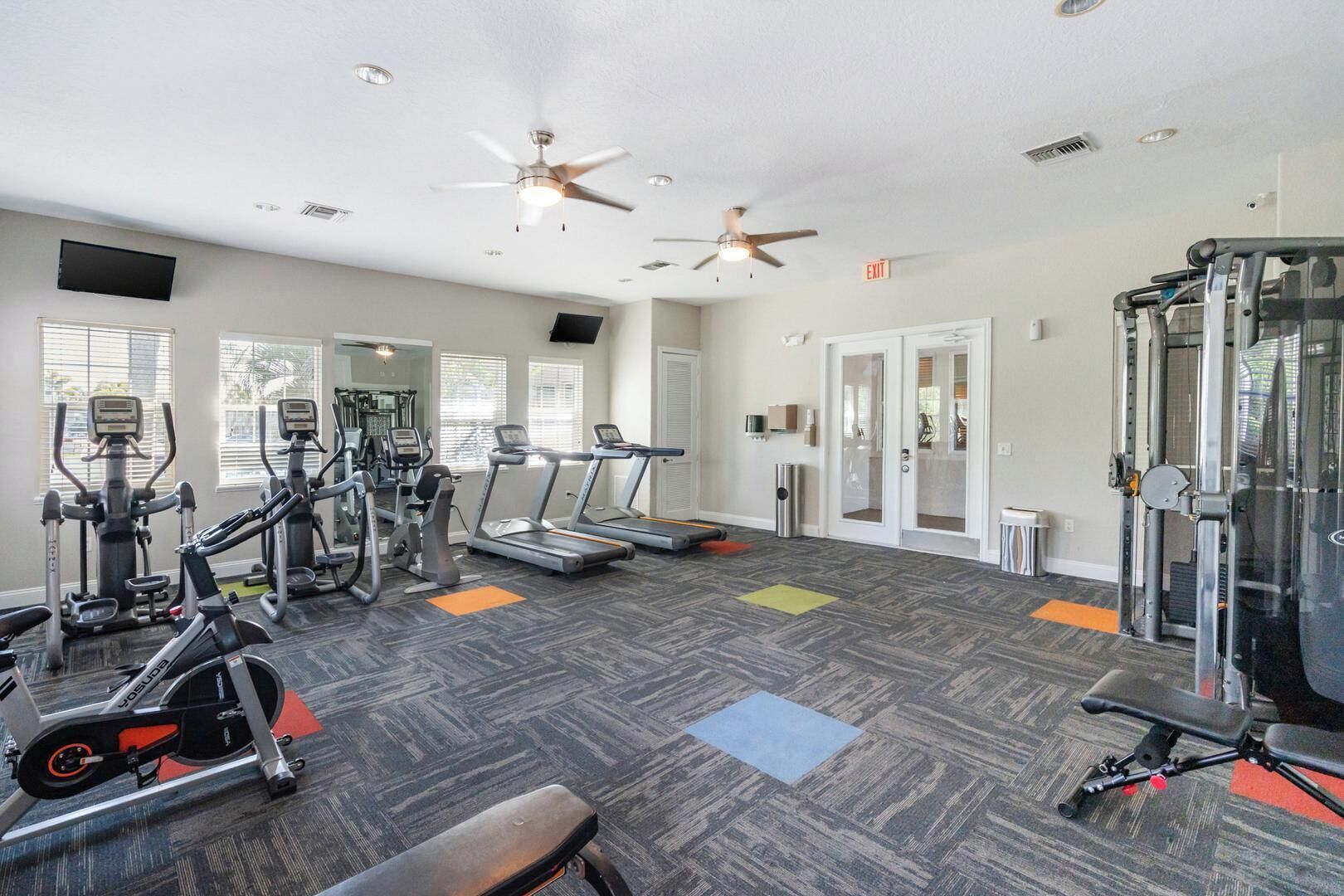 Ein Fitnessstudio mit Laufbändern, Crosstrainern, Fahrrädern und Gewichten.