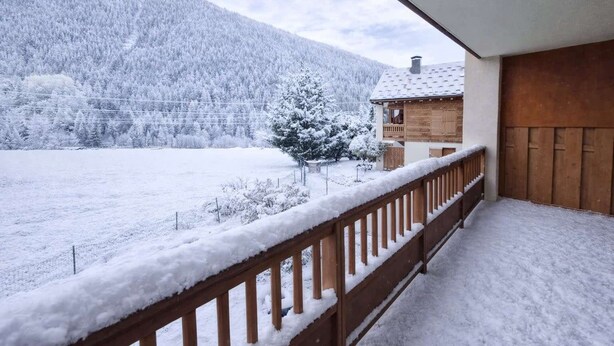 A balcony with a wooden railing overlooking a snow-covered landscape and a mountain. - Modern apartment in the heart of Séez (Séez)