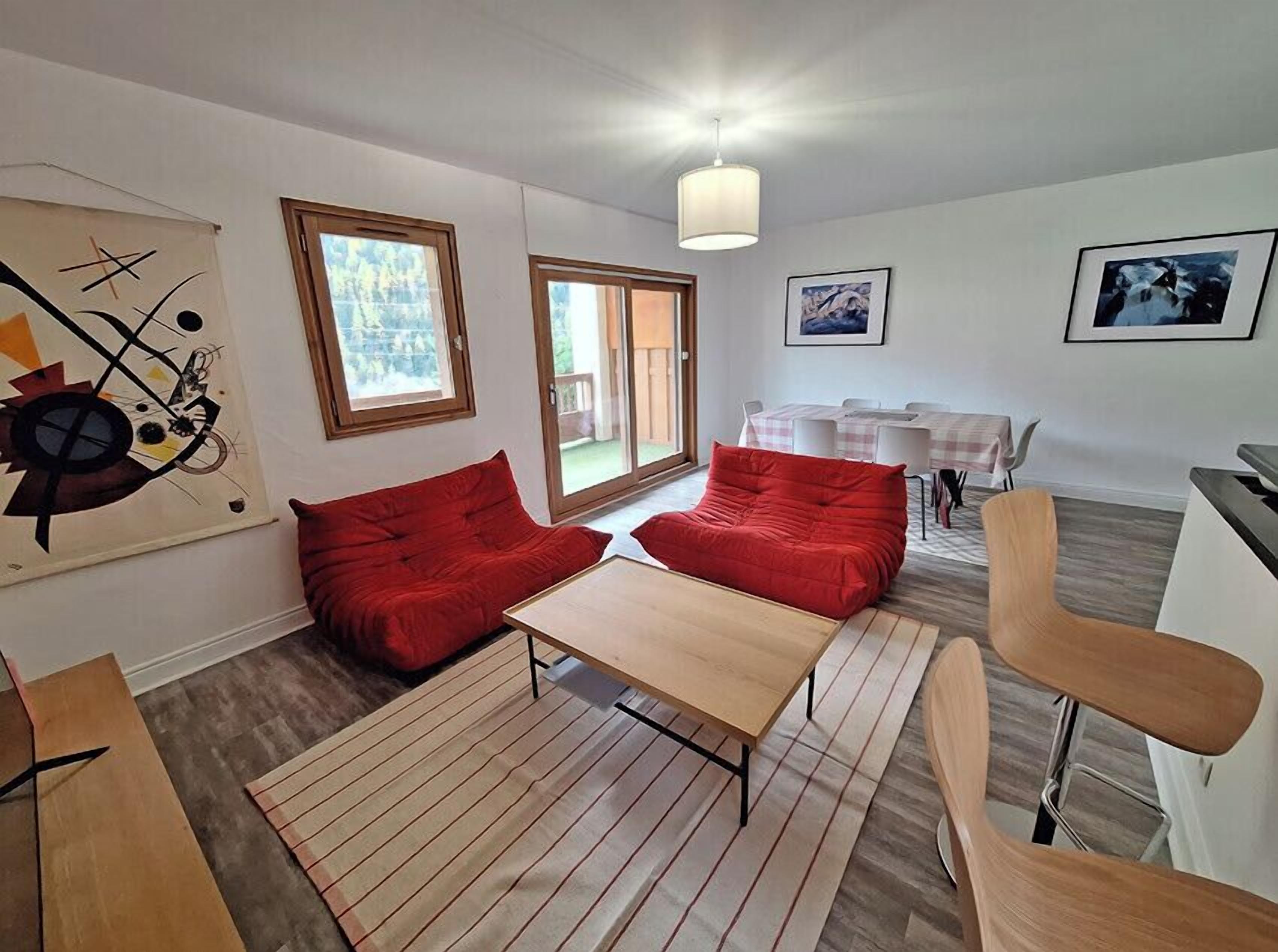 Ein modernes Wohnzimmer mit einer Couch, einem Couchtisch und einem Essbereich mit Tisch und Stühlen.
