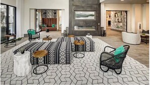 A spacious lobby with a high ceiling, patterned floor tiles, and a central seating area with a fireplace. - Landing | Stylish 1BD, Courtyard, Pool (Austin)