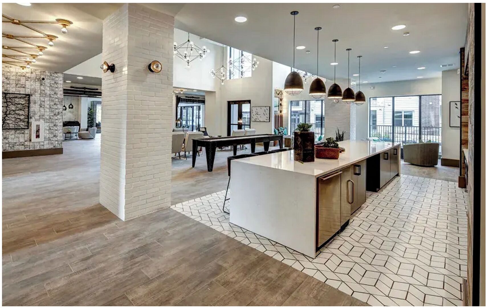 A spacious kitchen with a central island, pendant lighting, and a view of the dining area.
