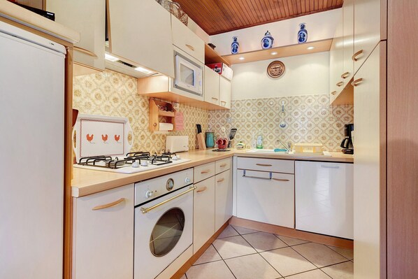 A kitchen with a refrigerator, stove, oven, microwave, and dishwasher.