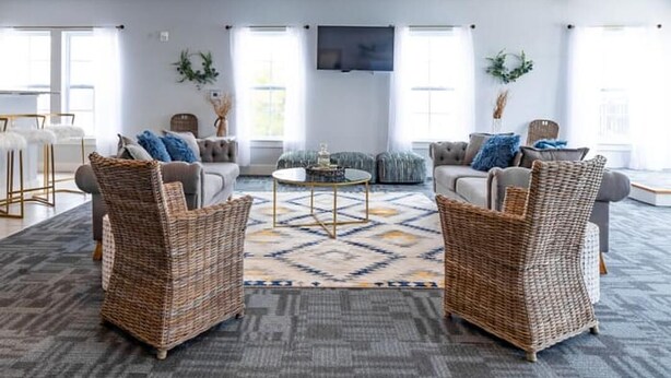 A modern living room with two wicker armchairs, a grey sofa, and a coffee table. - Landing | Incredible 2BD, Pool, Courtyard (Richmond)